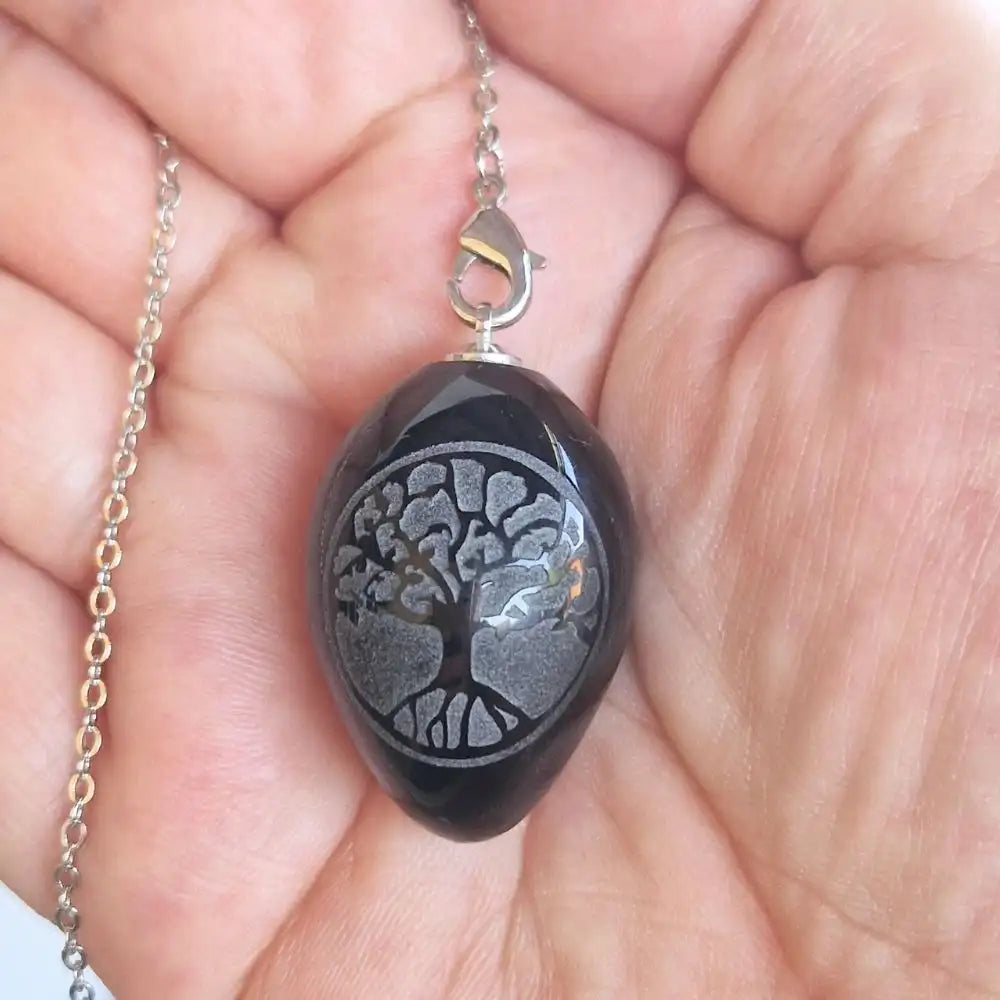 Pendule Arbre de Vie en obsidienne noire présenté dans une main
