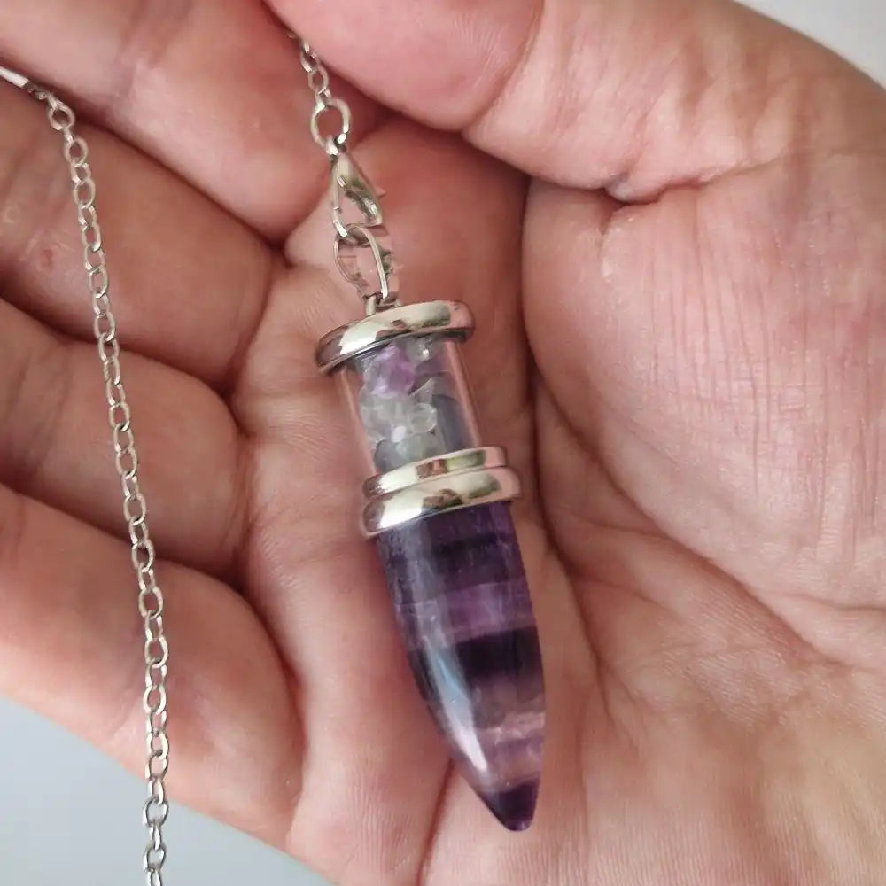 Pendule conique en fluorite tenu en main