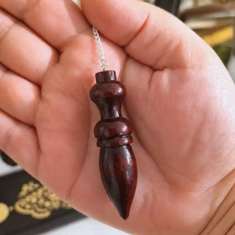 Pendule égyptien en bois de rose dans la main - taille