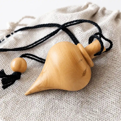 Gros plan sur un pendule goutte en bois de buis naturel