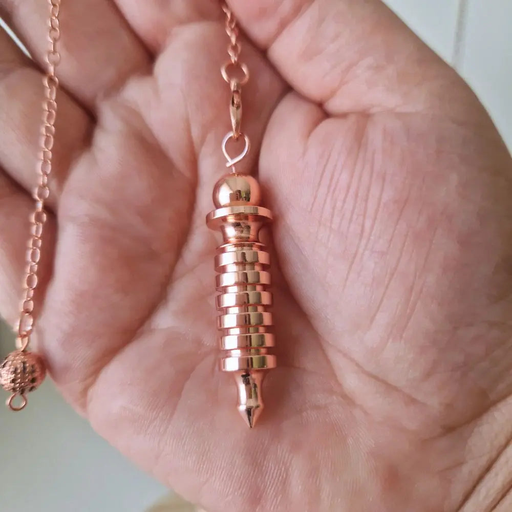 Pendule Isis couleur cuivre présenté dans la main