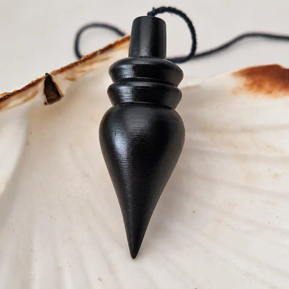 Gros plan sur un pendule Lotus en bois de buis noir