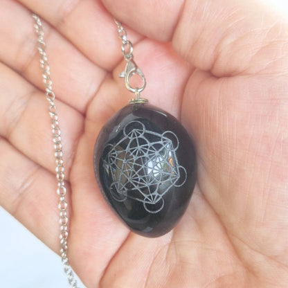 Pendule Métatron en obsidienne noire présenté dans une main