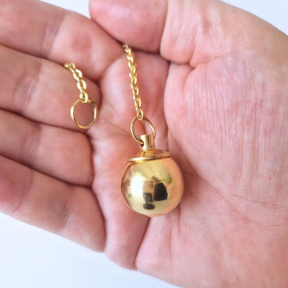 Pendule témoin sphère tenu en main