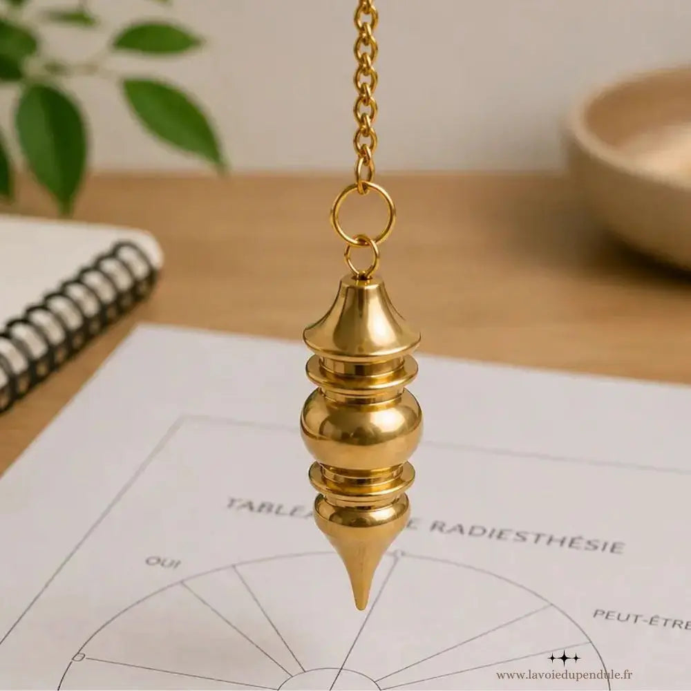Pendule en laiton Vénus utilisé sur une planche de radiesthésie